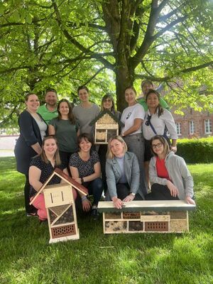 Gruppenfoto mit fertigen Insektenhotels nach einem Insektenhotelbau Teamevent/Teambuilding/Betriebsausflug von bo events in Gründau.