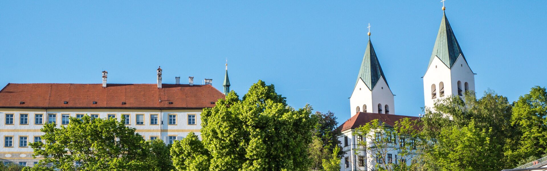 Versteckt hinter Bäumen erstreckt sich der Freisinger Dom