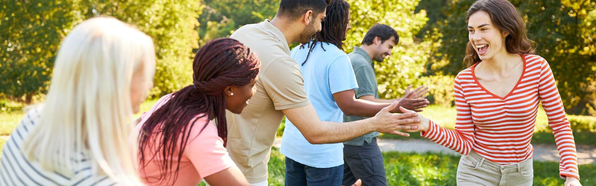 Eine Gruppe Personen steht in einer Reihe, während eine weitere Person mit ihrer Hand alle anderen Hände abklatscht bei einer Team Challenge 2.0 mit bo events