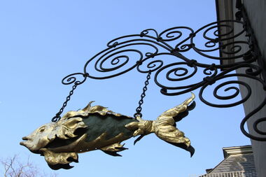 Fisch als Schild an Hausfassade